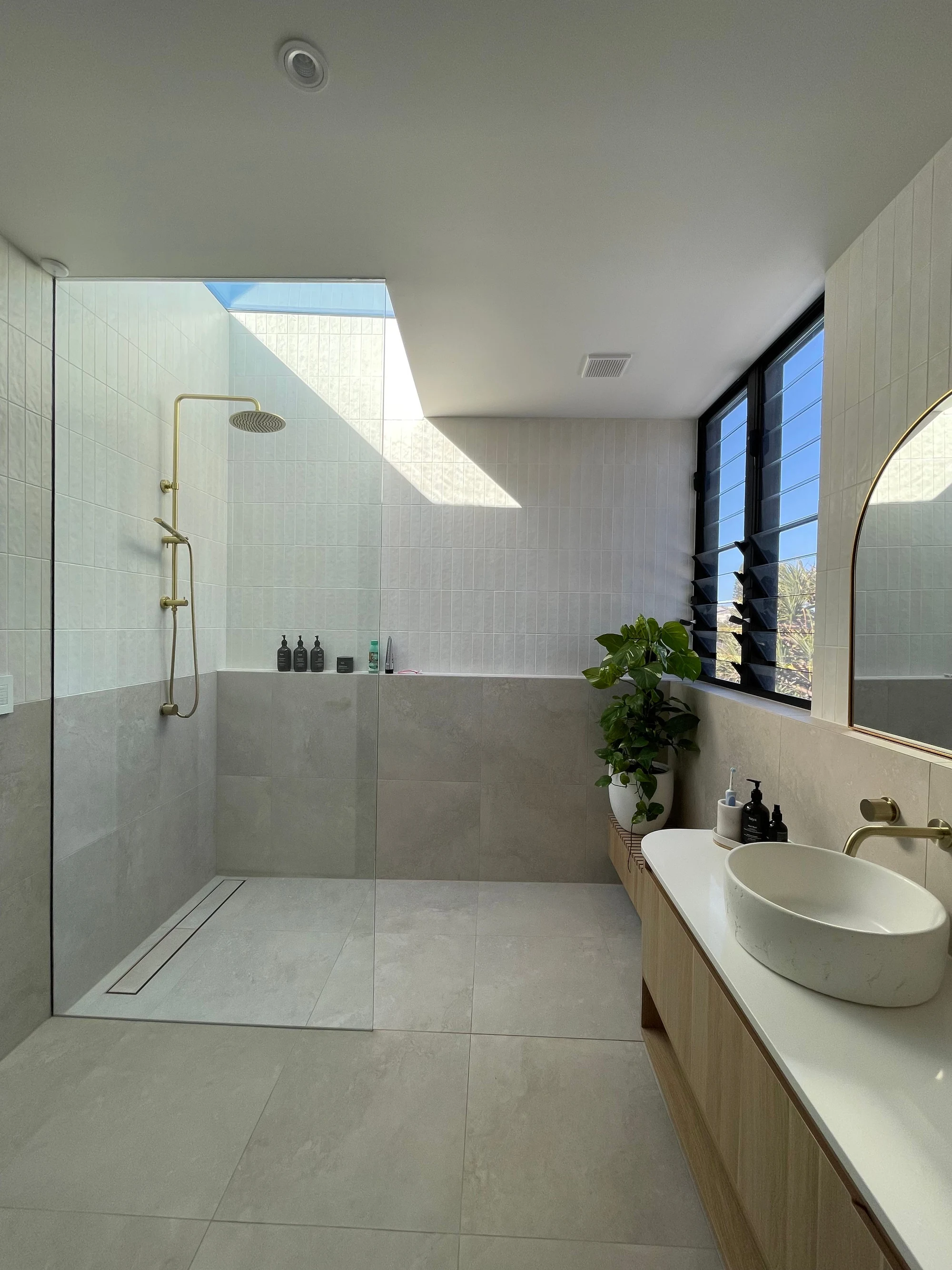 Bevilja House bathroom with skylight, glazed shower and floating vanity