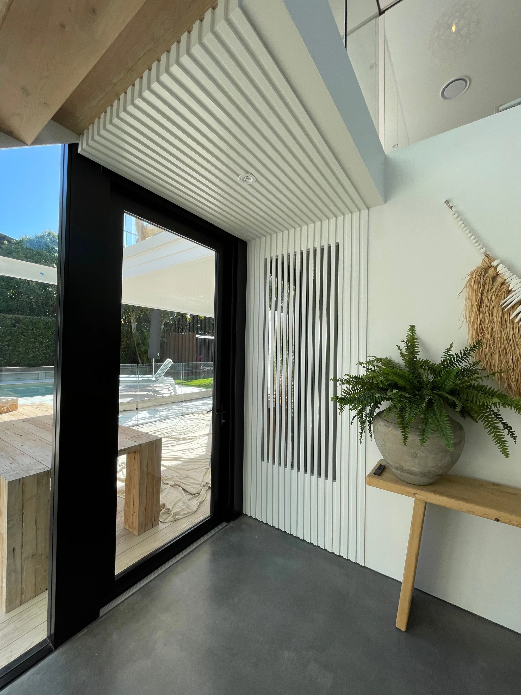 Bevilja House entry with glazed doors and timber battens