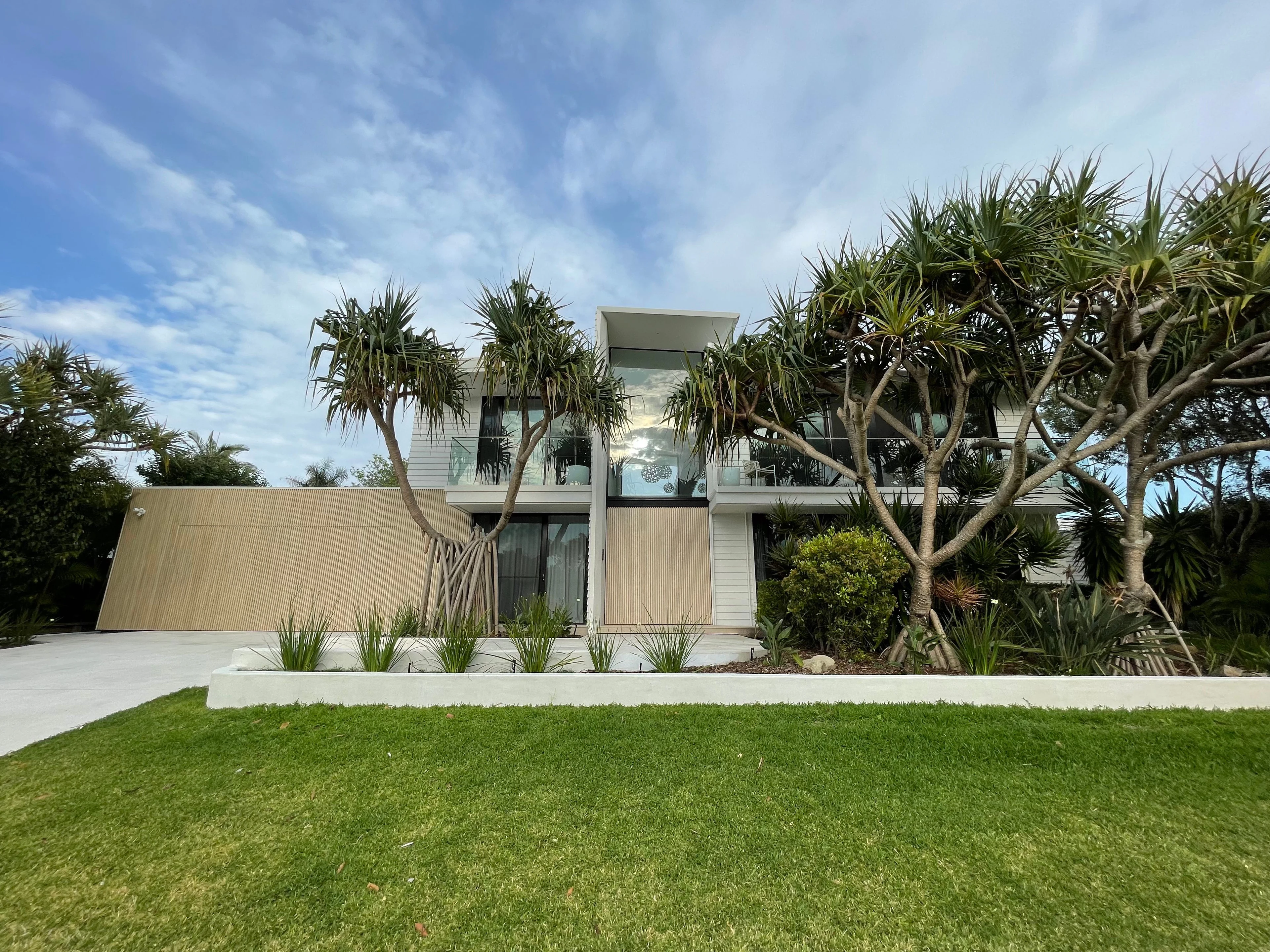 Bevilja House behind established coastal planting in Sunrise Beach