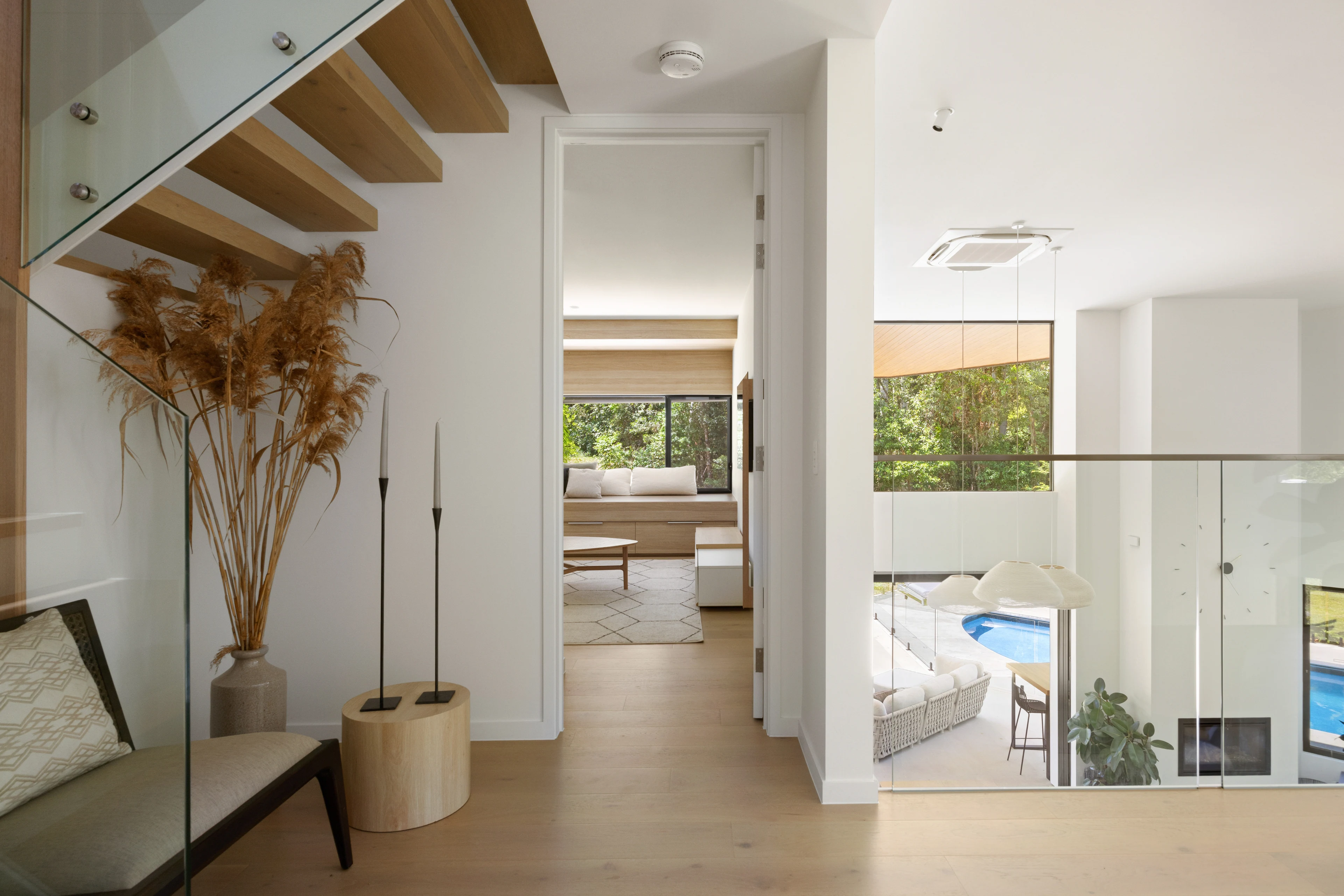 Floating timber staircase and bright entry at De Wald Haus