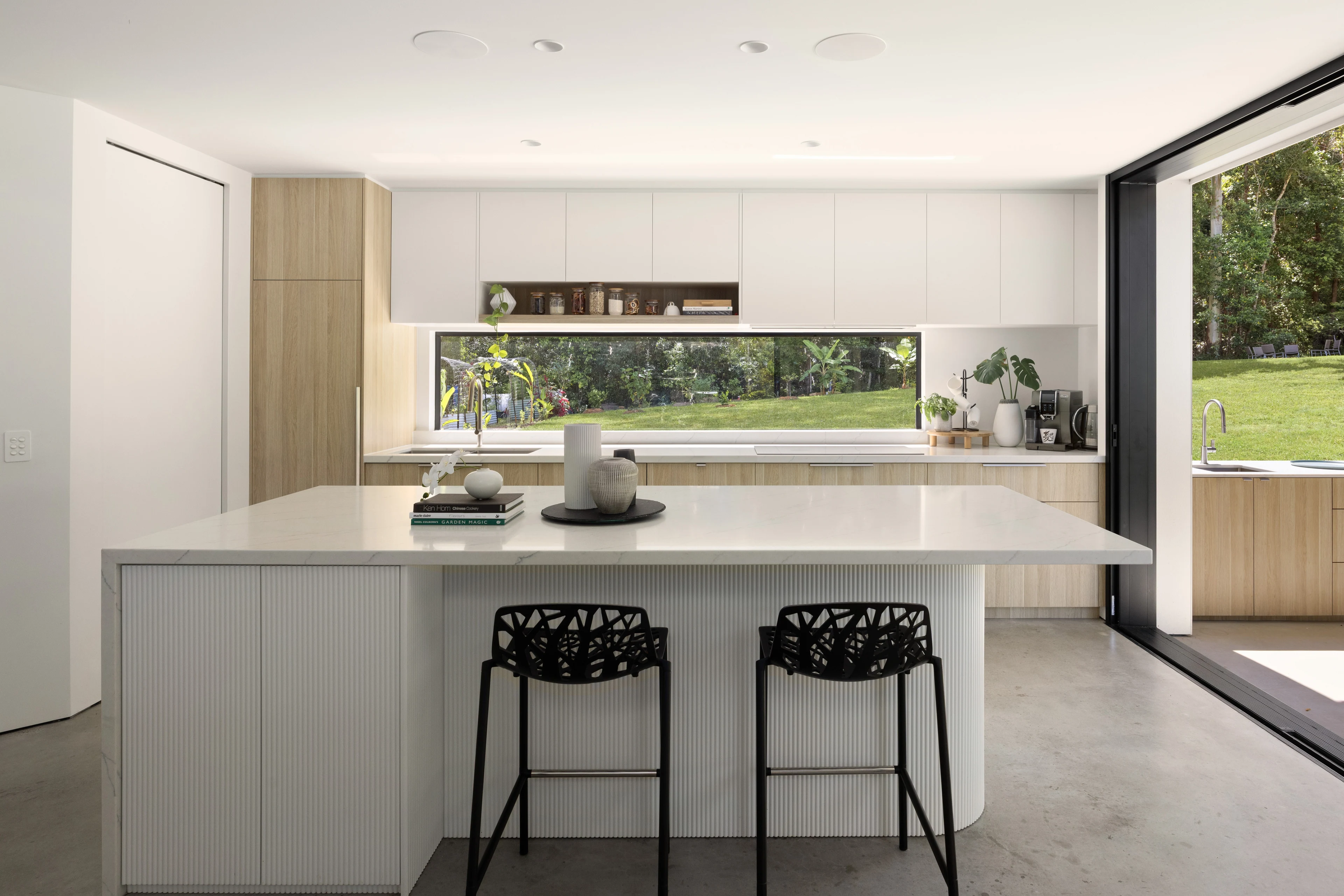 Pale stone island and timber kitchen joinery at De Wald Haus