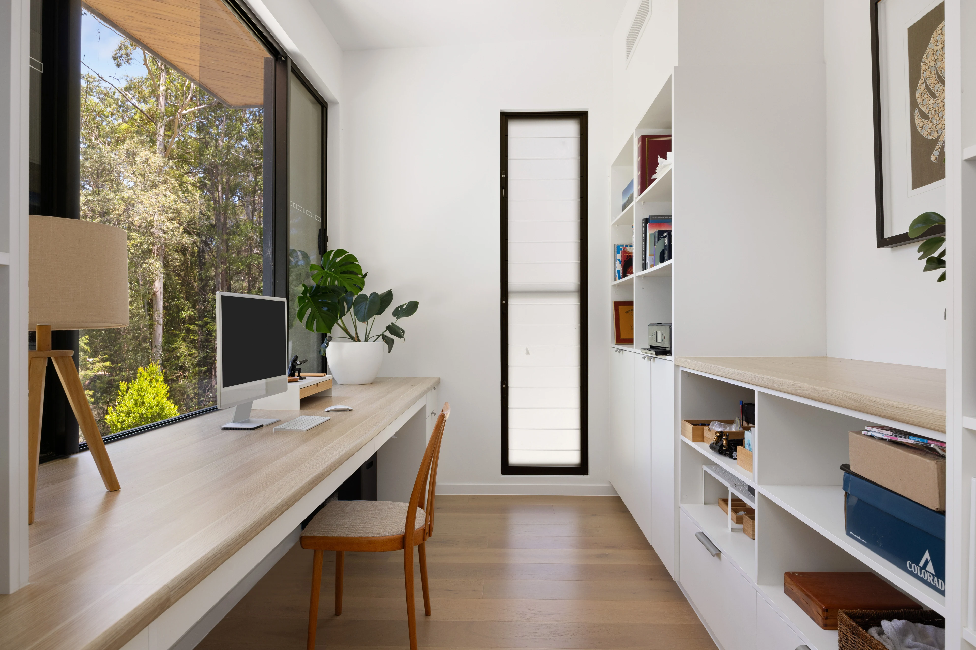 Built-in timber desk and shelving with a garden-facing window