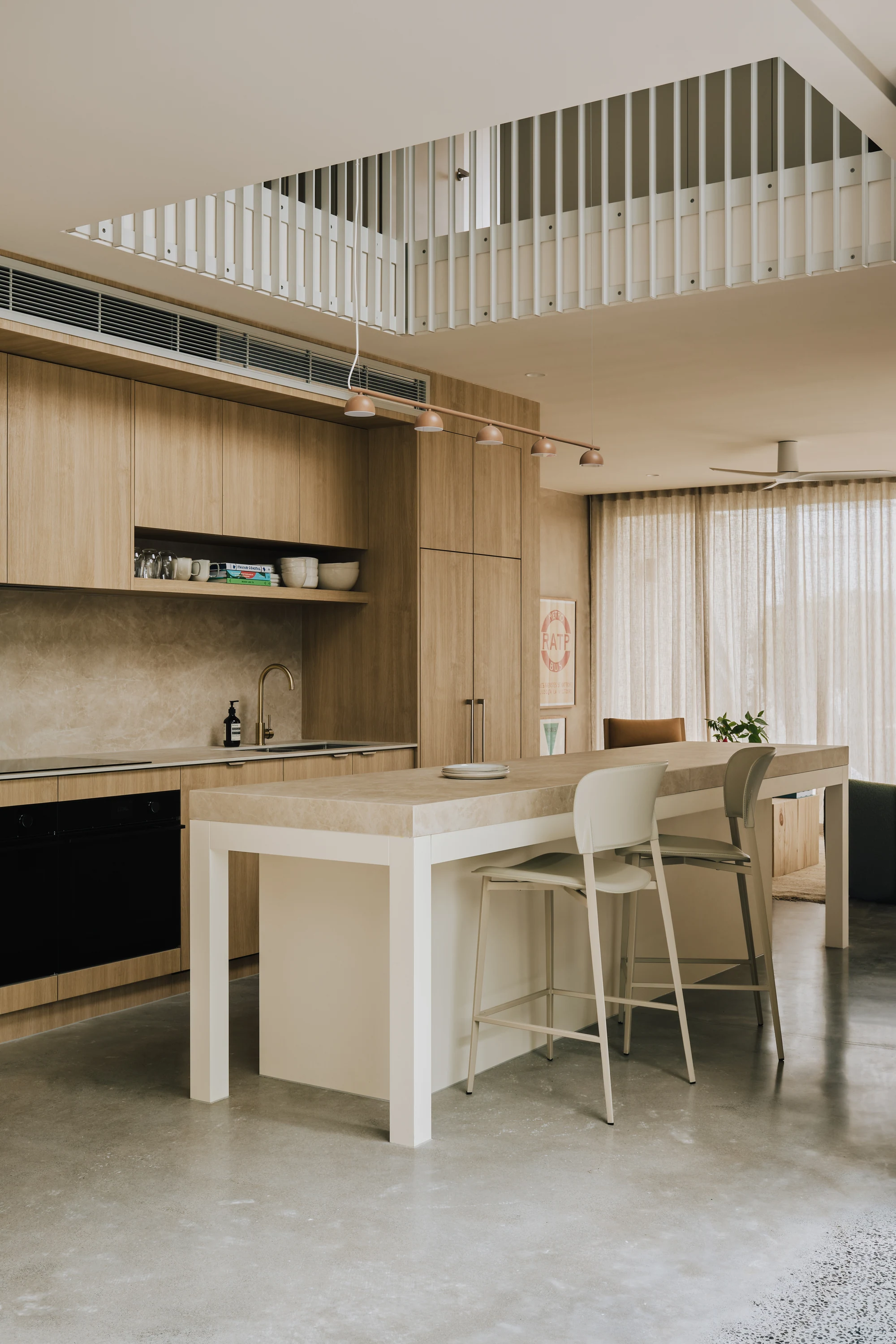 Palmera kitchen beneath a double-height void and timber balustrade