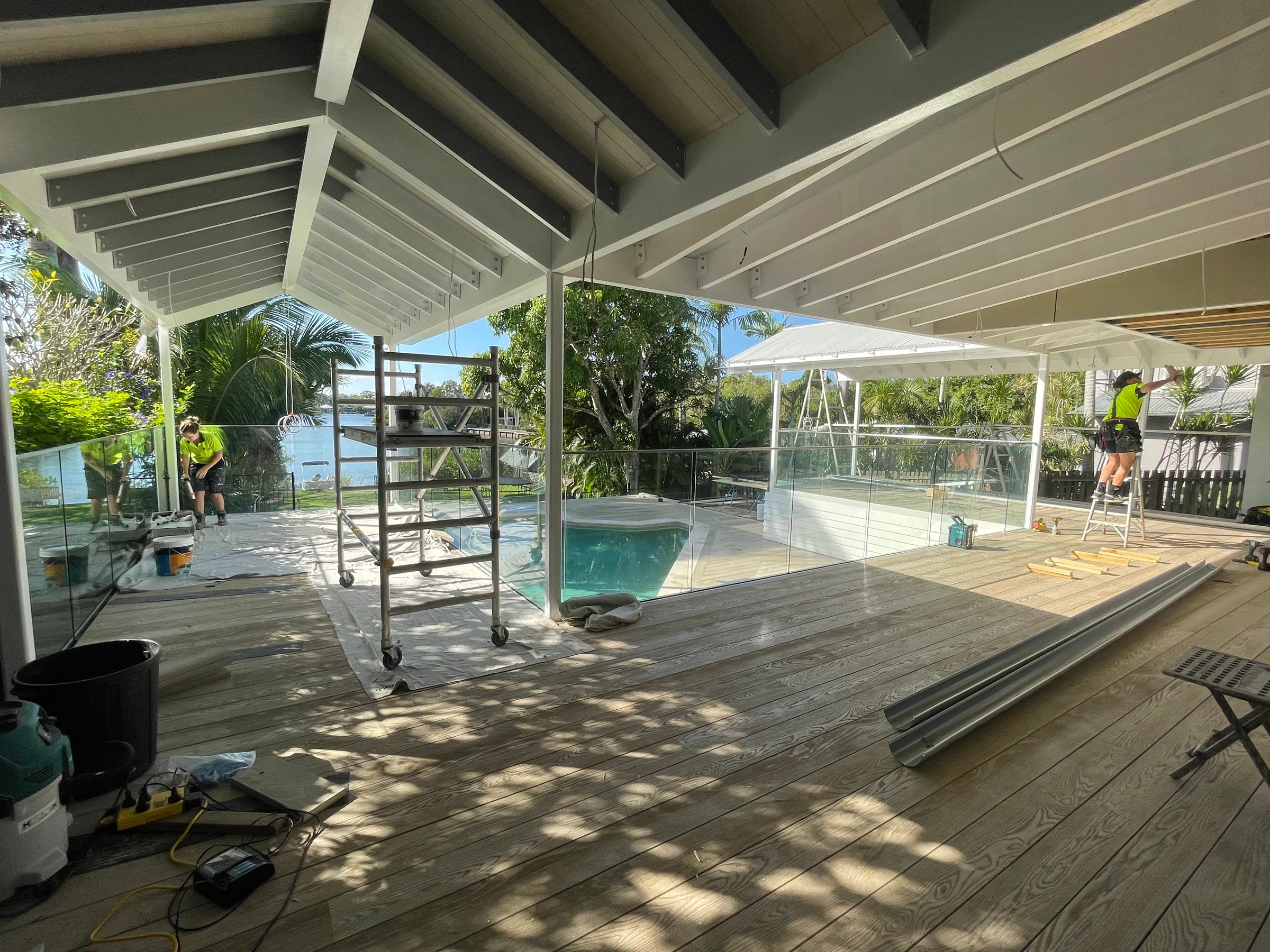 View beneath the Pavilion pergola with exposed roof beams and builders at work
