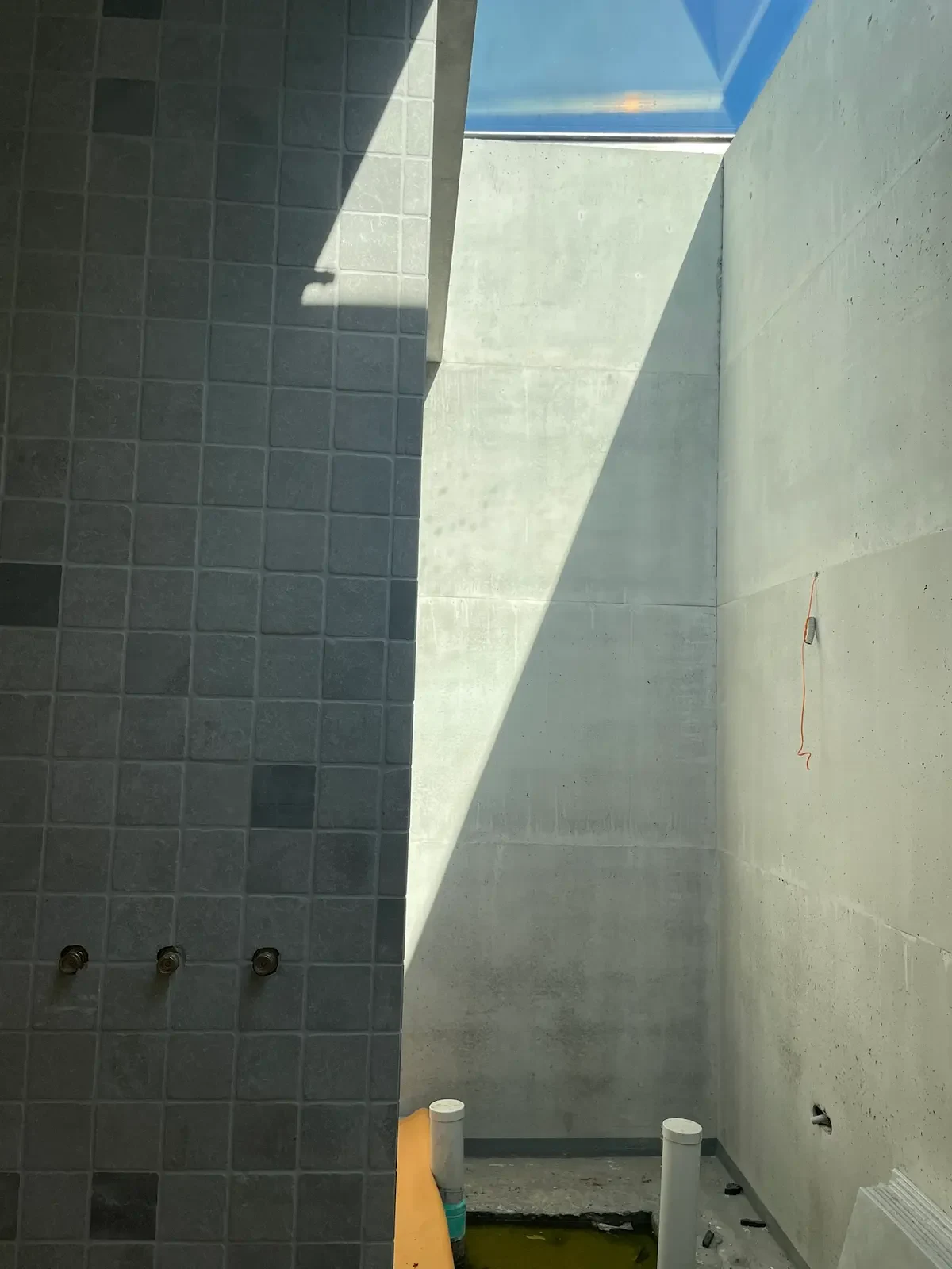 Daylight falling across tiled walls beneath a skylight at The Villa