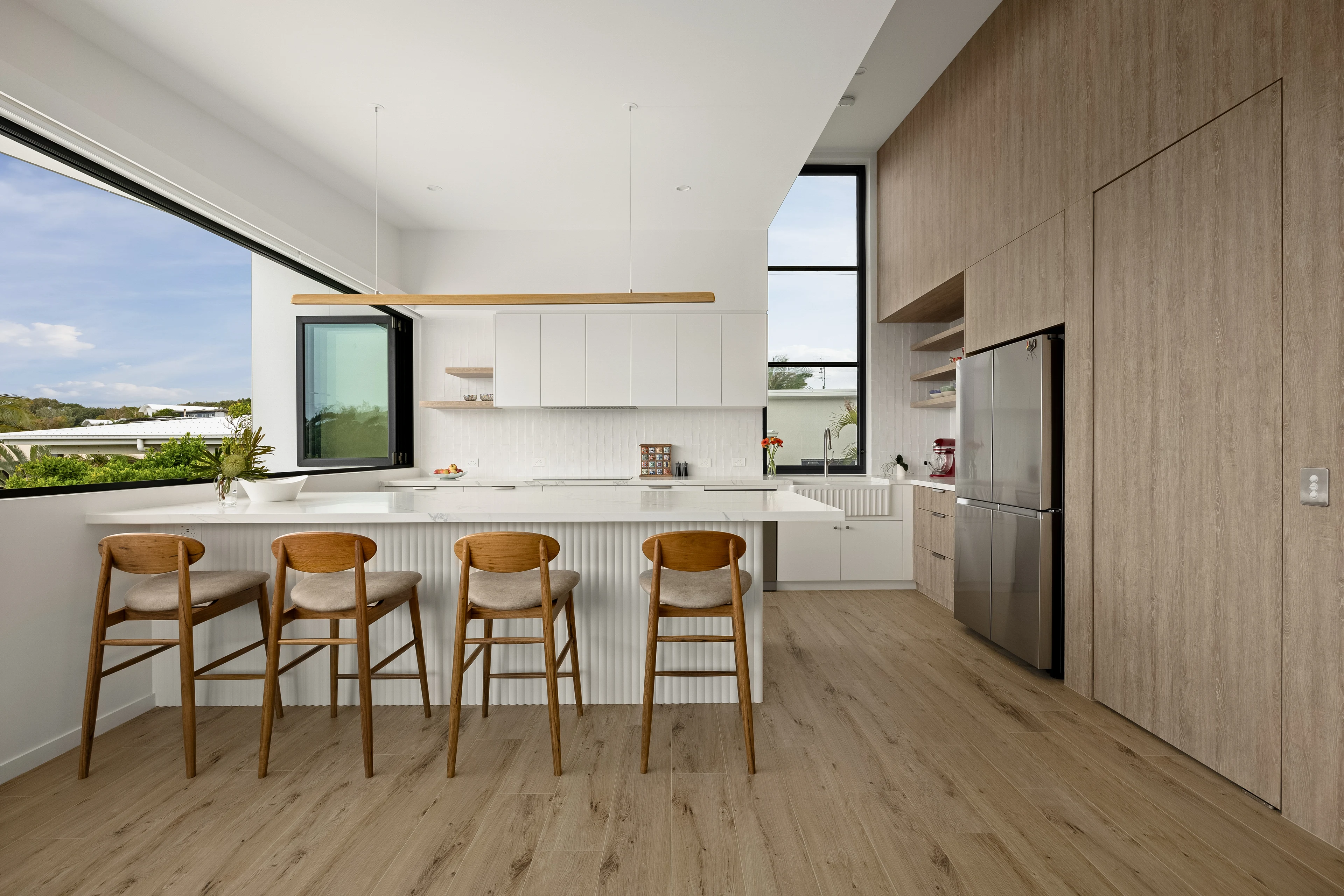 47 Wavecrest kitchen with timber joinery, pale stone and a coastal outlook