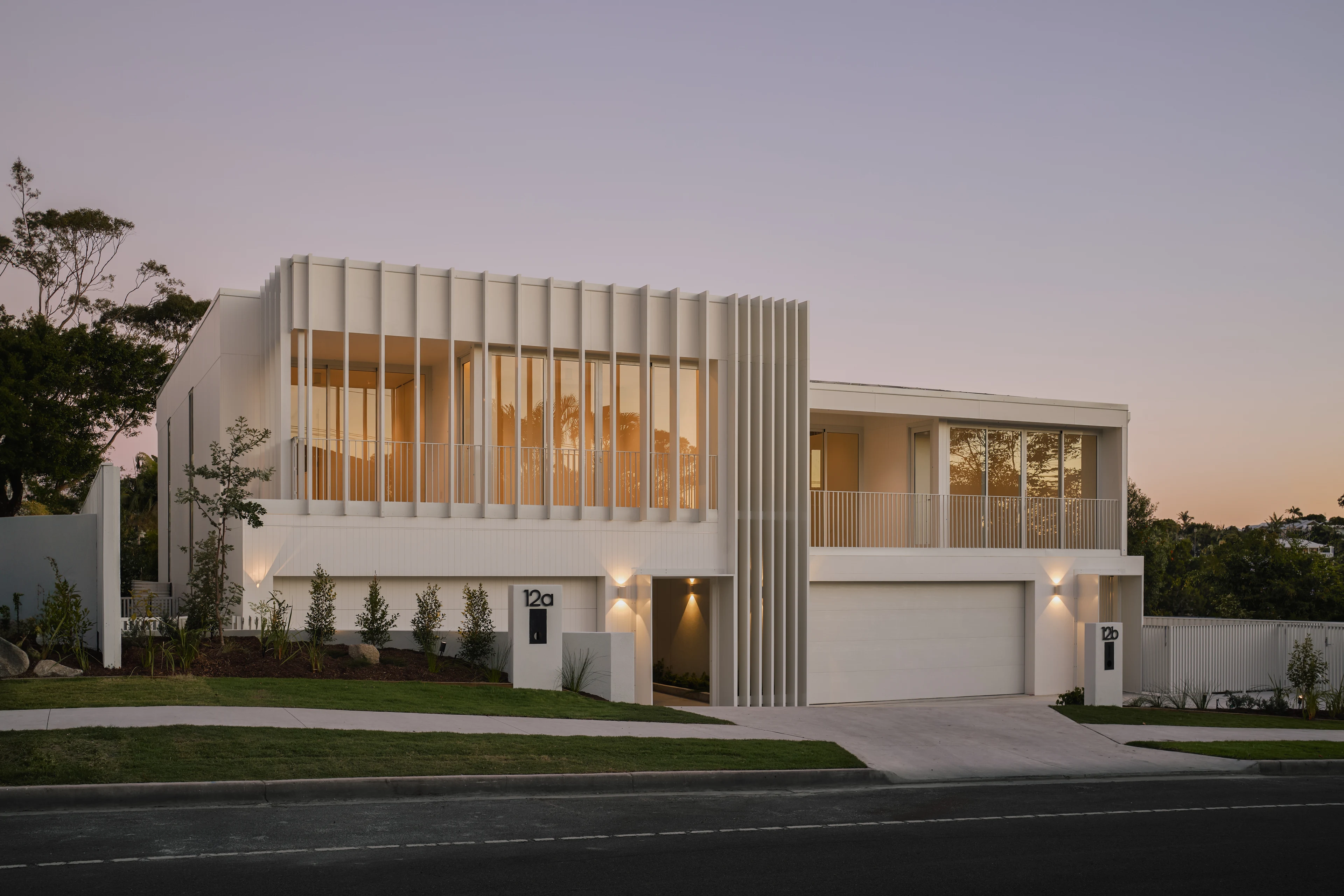 Timber-screened street elevation illuminated at dusk